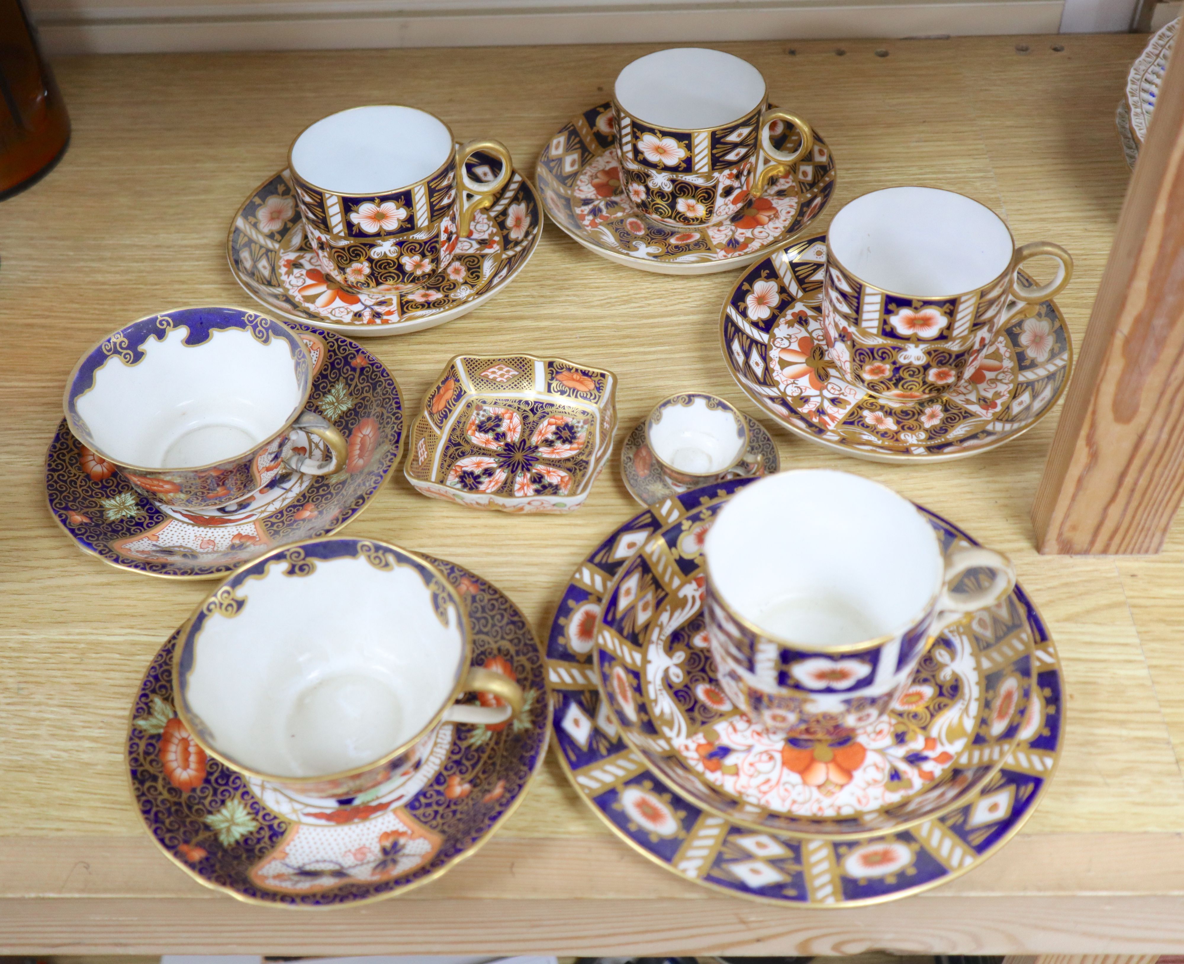 A collection of six Royal Crown Derby cups and saucers, a small square trinket dish and a miniature cup and saucer (16)